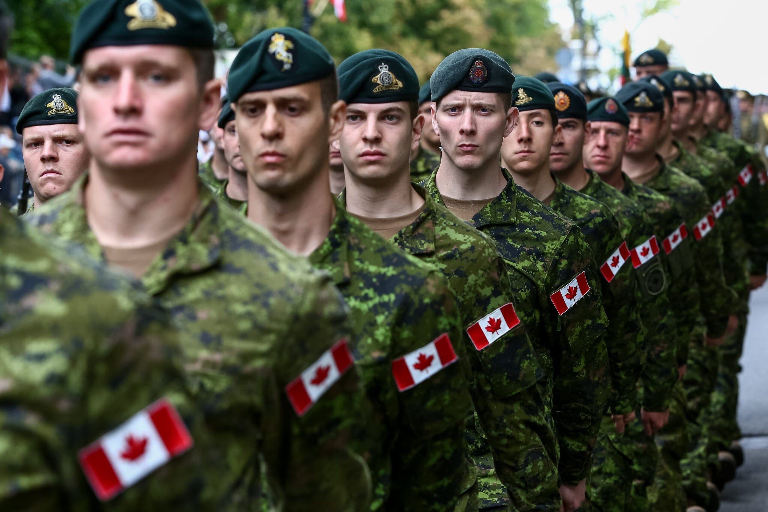 A row of soldiers with Canada flags on their arms