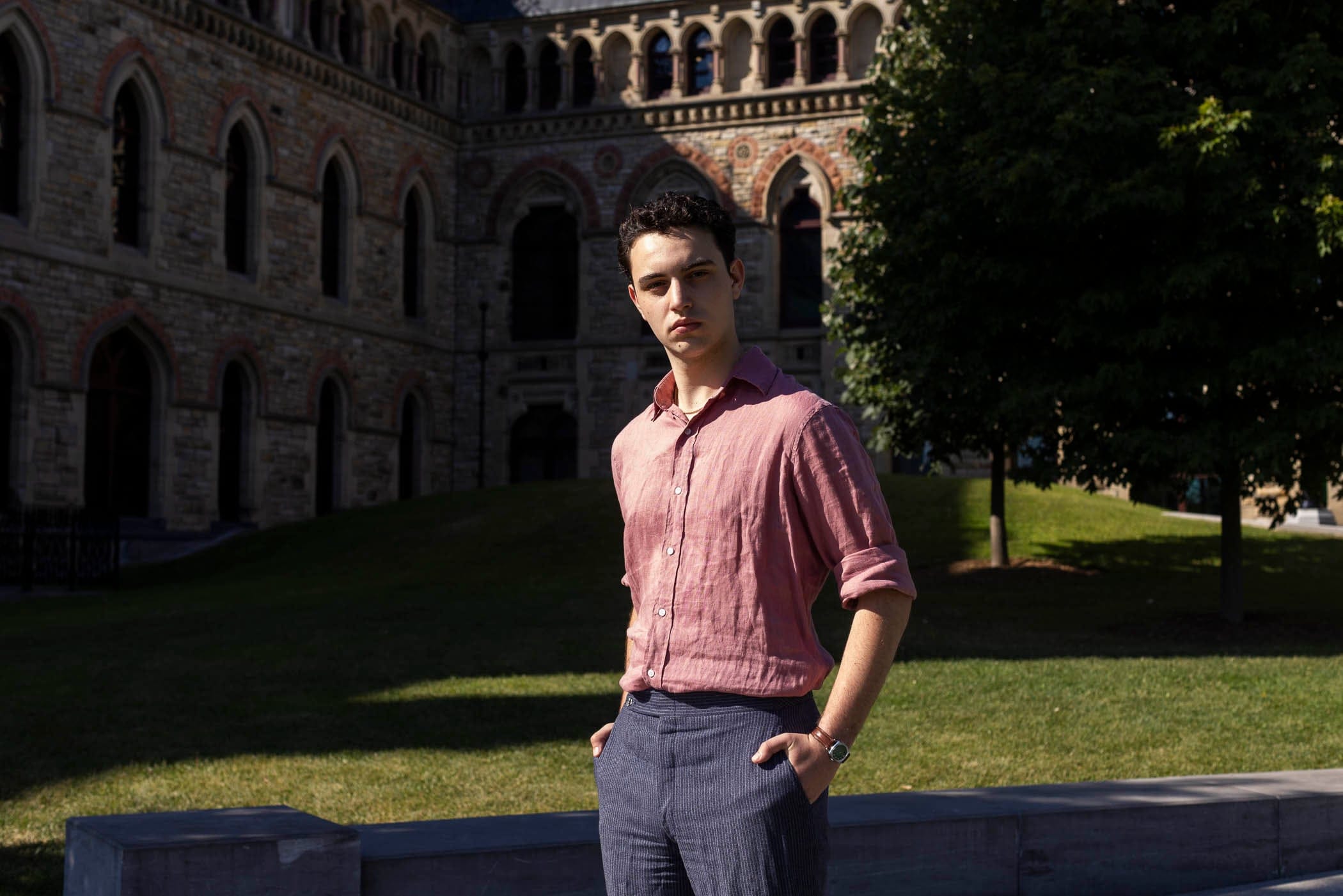 A young man in a button up and dress pants