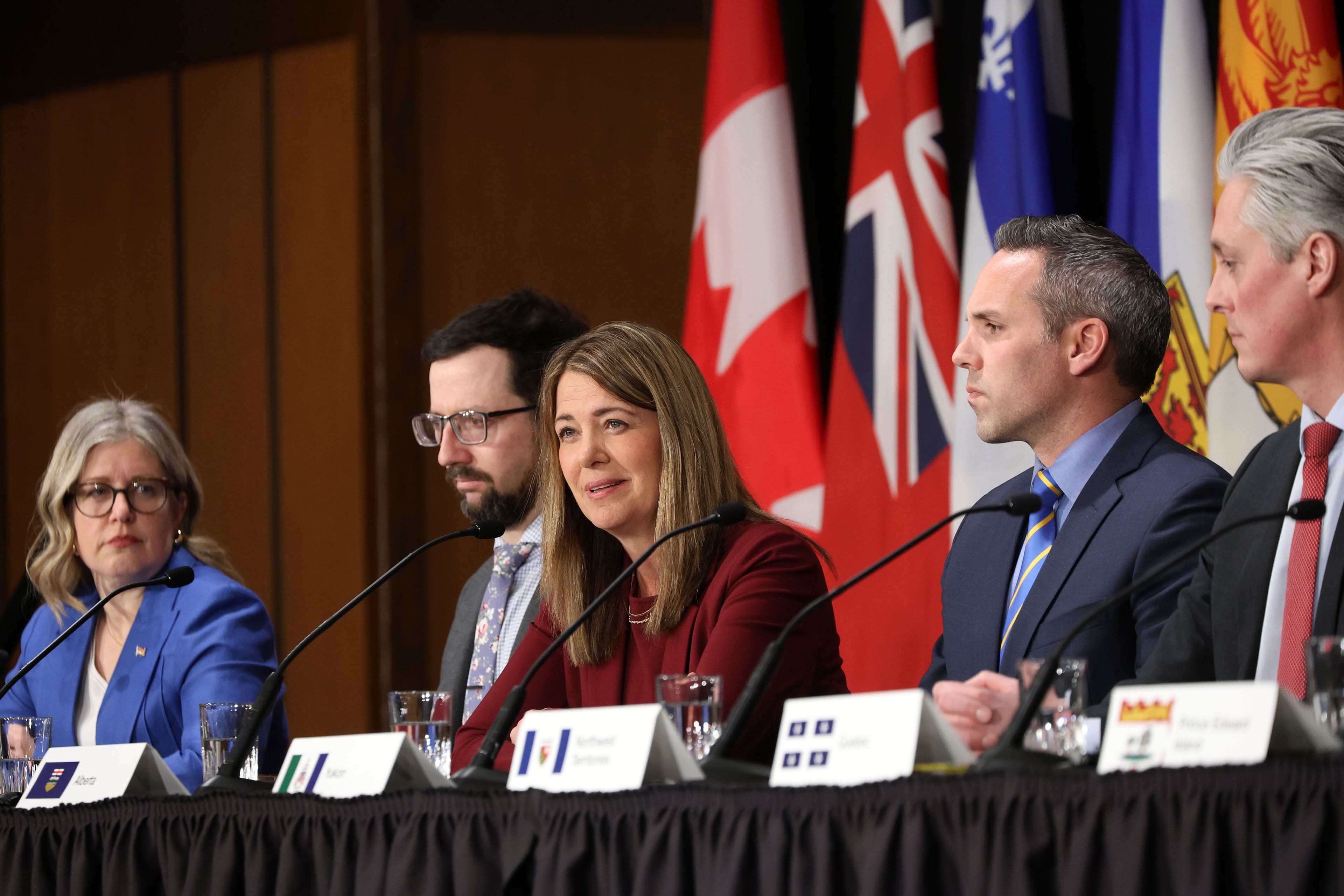 Premier Danielle Smith sitting at a table at a conference