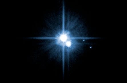 In 2005, this image from NASA's Hubble Space Telescope was used to identify two new moons orbiting Pluto. Pluto is in the center. The moon Charon is just below it. The newly discovered moons, Nix and Hydra, are to the right of Pluto and Charon. Image Credit: NASA, ESA, H. Weaver (JHU/APL), A. Stern (SwRI), and the HST Pluto Companion Search Team