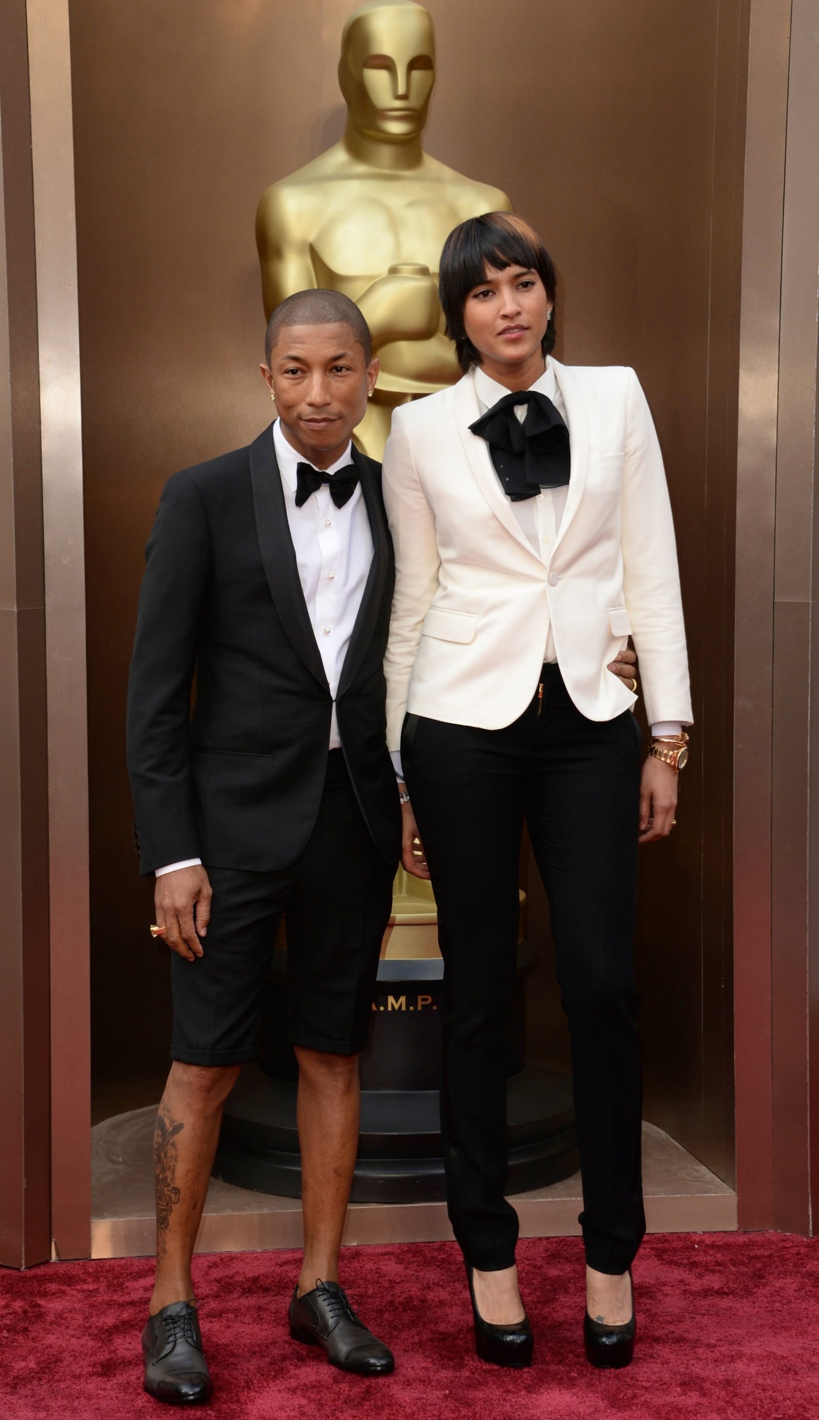 Pharrell Williams, here with his wife Helen Lasichanh, left his hat and big-boy pants at home and shows off his leg tats in a Buster Brown tuxedo.