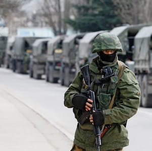 Armed servicemen wait in Russian army vehicles outside a Ukranian border guard post in the Crimean town of Balaclava