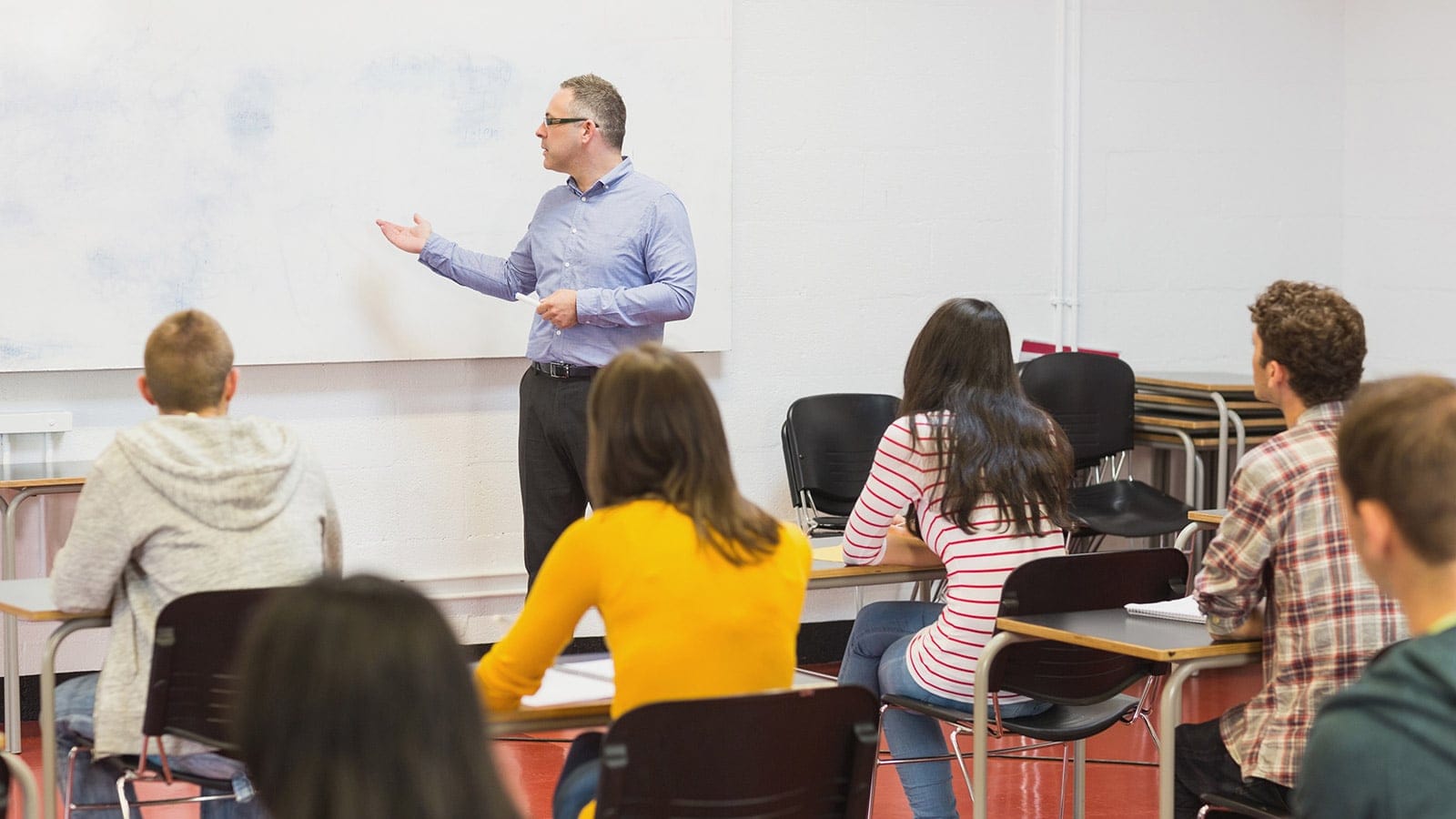 Attentive students with teacher in the classroom