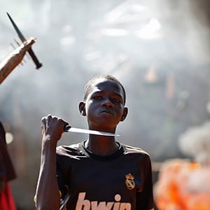 A boy gestures in front of a barricade on fire during a protest after French troops opened fire at protesters blocking a road in Bambari