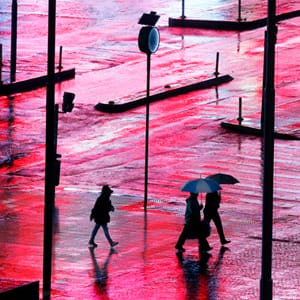 A pedestrian holds an umbrella in the colours of the Argentinian national flag during a rainy day on the 9 de Julio Avenue in Buenos Aires