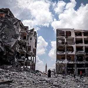 Palestinians walk in front of buildings destroyed by Israeli military forces in the northern Gaza Strip town of Beit Lahiya. Emad Nasser/Flash90/Redux