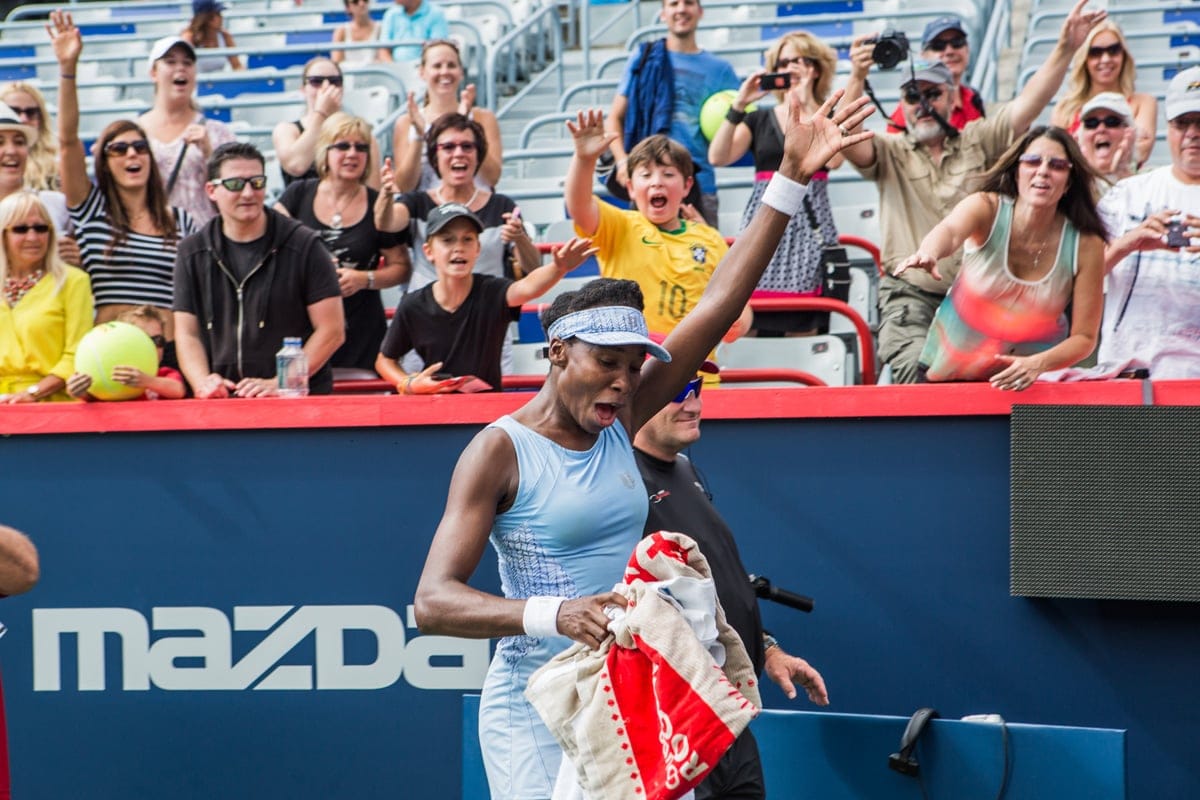 Venus Williams is all smiles and handing out towels to the crowd after winning here semi final match versus her sister, Serena Williams at the Rogers Cup in Montreal on August 9th, 2014.
(Photograph by Will Lew)