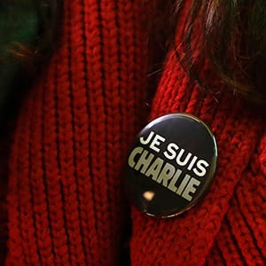 Woman wears a pin during a vigil outside the Consulate General of France to pay tribute to the victims of the suspected Islamist attack on satirical magazine Charlie Hebdo in Paris, in San Francisco