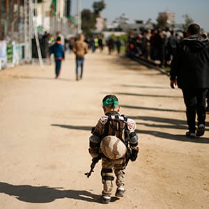A Palestinian boy wearing a military costume arrives at a military-style graduation ceremony for Palestinian youths who were trained at one of the Hamas-run Liberation Camps, in Gaza City