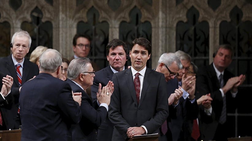 Liberal leader Trudeau receives a standing ovation from his caucus in the House of Commons in Ottawa. (CP Photo)