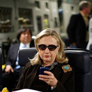 U.S. Secretary of State Hillary Clinton checks her PDA upon her departure in a military C-17 plane from Malta bound for Tripoli, Libya