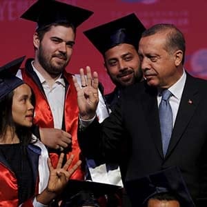 Turkey's President Tayyip Erdogan chats with students during a graduation ceremony in Ankara, Turkey, June 11, 2015. President Erdogan on Thursday urged the country's political parties to work quickly to form a new government, saying egos should be left aside and that history would judge anyone who left Turkey in limbo. In his first public appearance since Sunday's parliamentary election, Erdogan said no political development should be allowed to threaten Turkey's gains. He said he would do his part in finding a solution with the powers given to him by the constitution. (Umit Bektas/Reuters)