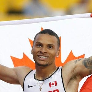 Andre De Grasse, of Canada, holds a flag after he wins the gold medal in the men's 100m final during the athletics competition at the 2015 Pan Am Games in Toronto on Wednesday, July 22, 2015. THE CANADIAN PRESS/Mark Blinch