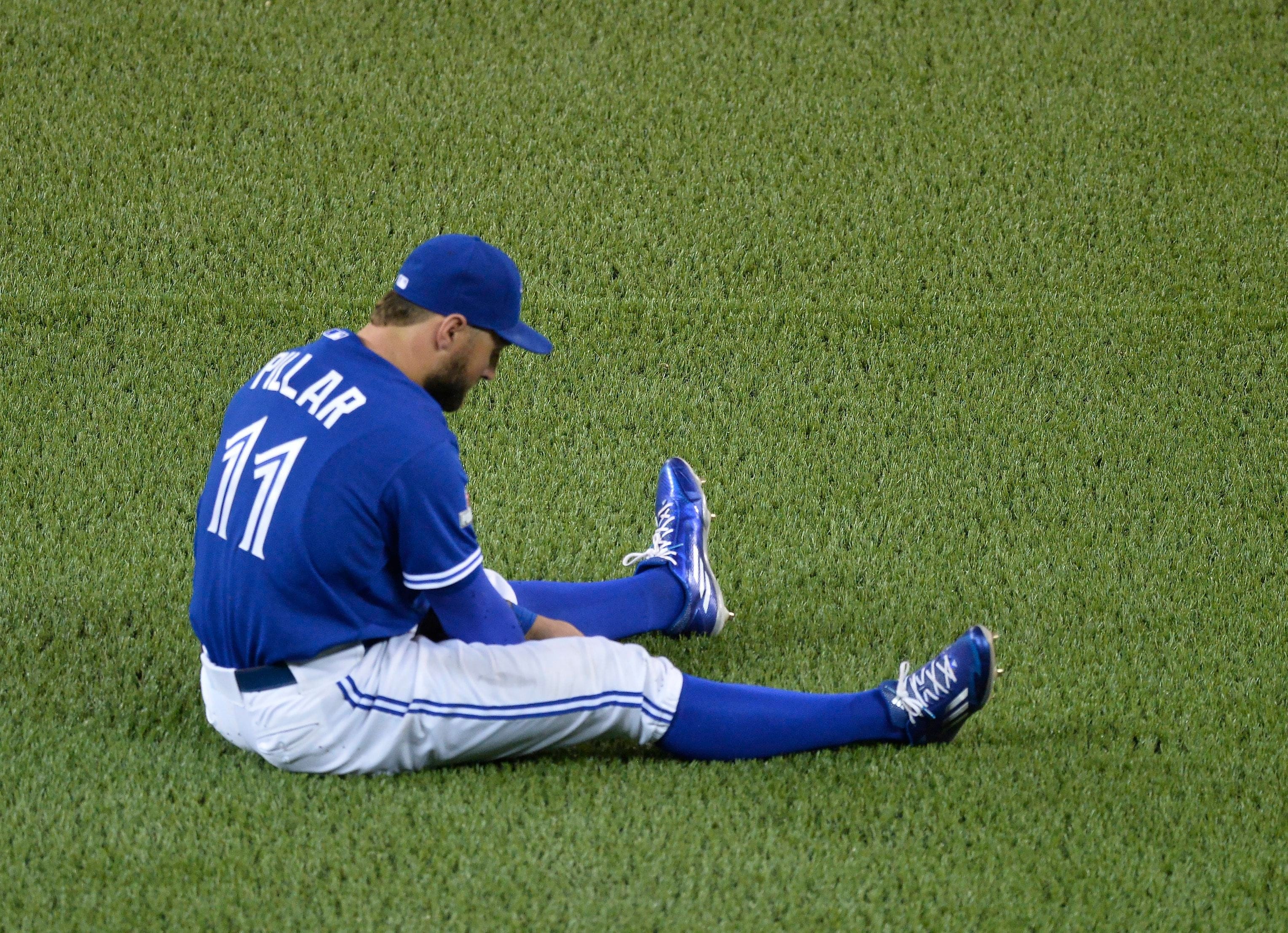 Toronto Blue Jays' Kevin Pillar sits in the outfield after Kansas City Royals' Lorenzo Cain hits a two run RBI single during seventh inning game four ALCS playoff baseball action in Toronto on Tuesday, October 20, 2015. THE CANADIAN PRESS/Chris Young
