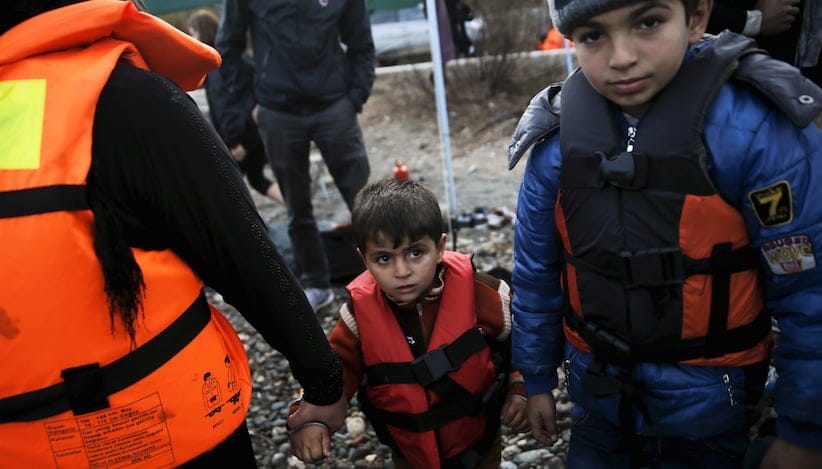 A Syrian refugee family is seen on a beach moments after arriving on a raft on the Greek island of Lesbos, November 10, 2015. Since the start of the year, over 590,000 people have crossed into Greece, the frontline of a massive westward population shift from war-ravaged Syria and beyond. REUTERS/Alkis Konstantinidis - RTS6A2F