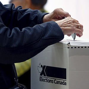 A voter casts her ballot at a polling station in Quebec City, October 19, 2015. Canadians go to the polls in a federal election on Monday. REUTERS/Mathieu Belanger - RTS54D1