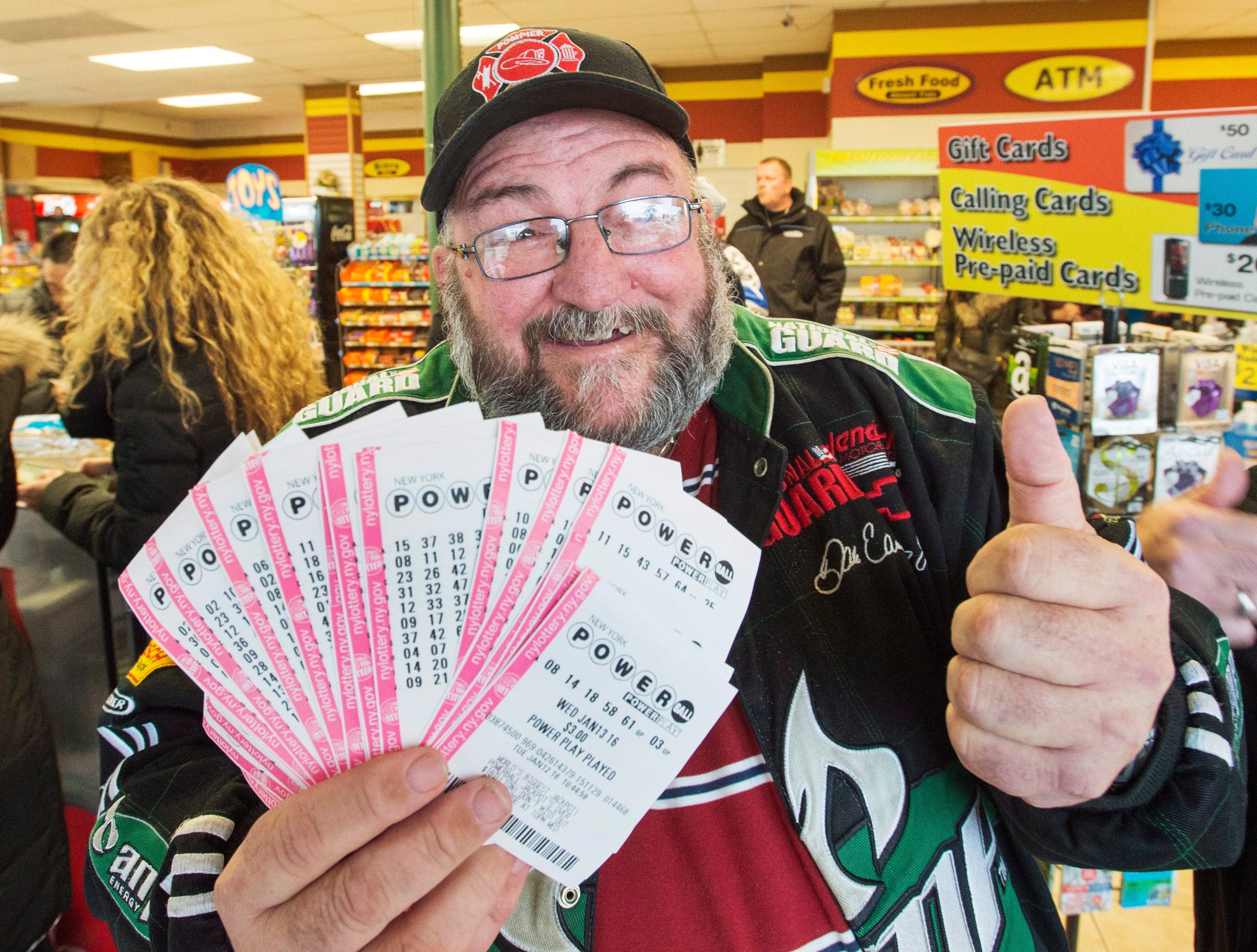 Robert Charbonneau, from St-Donat, Que., holds up $1,000 worth of Powerball tickets for himself and his friends at a convenience store, Tuesday, January 12, 2016 in the border town of Champlain, N.Y. The jackpot has reached a record setting $1.5 billion. THE CANADIAN PRESS/Ryan Remiorz