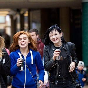 Teenage girls singing as they walk through the shopping precinct drinking Monster energy drinks in the Broadgate shopping precinct, Coventry. (John Harris/REPORT DIGITAL-REA/Redux)