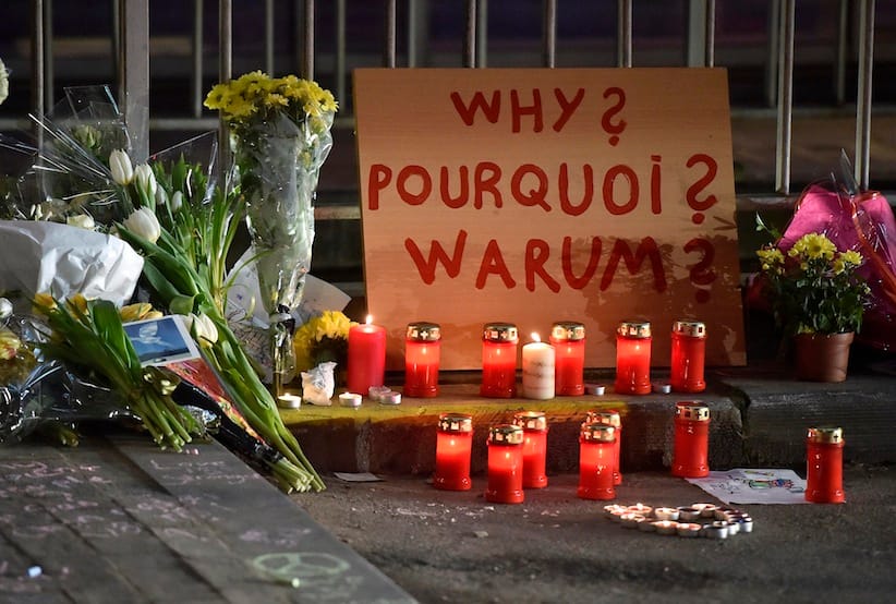 A sign reads "Why?" in English, French and Flemish behind candles and flowers near the Maelbeek metro station, in Brussels on Wednesday evening, March 23, 2016. Bombs exploded Tuesday at Brussels airport and one of the city's metro stations, killing and wounding scores of people, as a European capital was again locked down amid heightened security threats. (AP Photo/Martin Meissner)