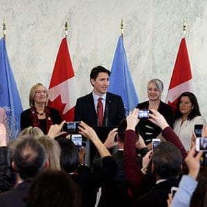 Canadian Prime Minister Justin Trudeau (C) addresses members of the media during his arrival to United Nations Headquarters in New York, New York, USA, 16 March 2016. Others are not identified. Trudeau later the same day was scheduled to meet with UN Secretary General Ban Ki-moon. (Jason Szenes/EPA/CP)