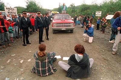 Two protestors block logging trucks to Clayoquot valley as police prepare to move in near Tofino July 1993. Eleven were arrested bringing to the total number of arrests to over 140 since the blockade began July 5. (Chuck Stoody/CP)