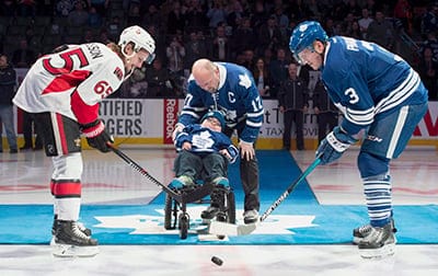 Former Toronto Maple Leafs captain Wendel Clark and 11-year-old Garrett Gamble Jr., centre, drop the ceremonial puck for Ottawa Senators' Erik Karlsson, left, and Toronto Maple Leafs' Dion Phaneuf prior to NHL action in Toronto on Saturday, March 28, 2015. (Frank Gunn/CP)