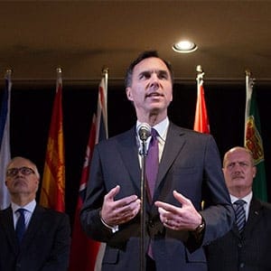 Federal Finance Minister Bill Morneau, centre, is flanked by his provincial and territorial counterparts as he speaks during a news conference after reaching a deal to expand the Canada Pension Plan, in Vancouver, B.C., on Monday June 20, 2016. (Darryl Dyck/CP)