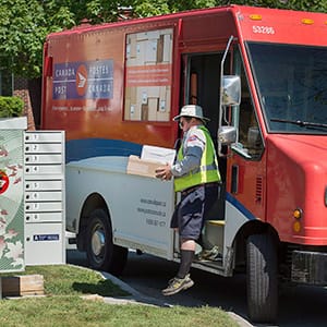 A Canada Post employee fills a community mail box in Dartmouth, N.S. on Thursday, June 30, 2016. (Andrew Vaughan/CP)