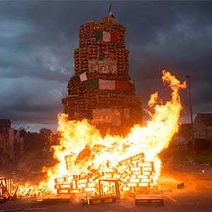 A smaller bonfire is lit before midnight for the children to watch. On the larger bonfire in Bloomfield Walkway bonfire in East Belfast, Irish flags and political posters of Sinn Féin, the main Nationalist party in Northern Ireland, are on the bonfire to be burned. (Photograph by Paul Colangello)
