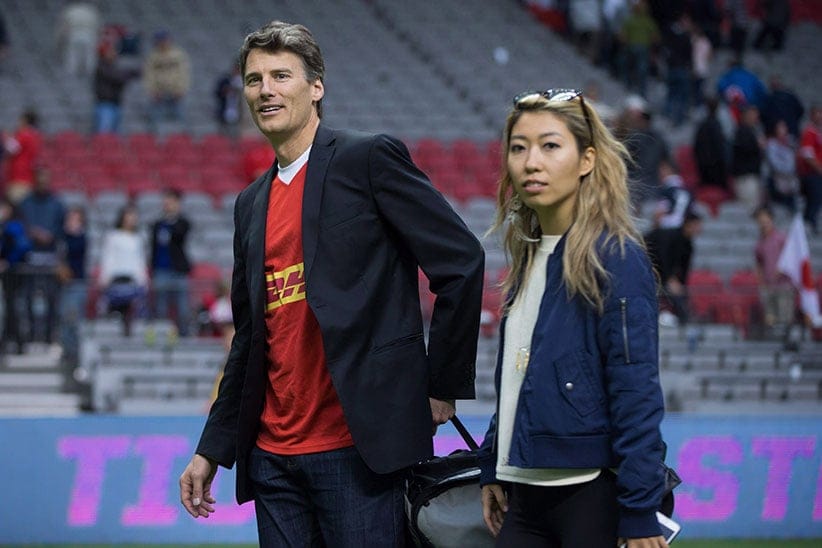 Vancouver Mayor Gregor Robertson, left, and singer-songwriter Wanting Qu leave the field after Robertson presented the man of the match award after Canada and Japan played a rugby test match in Vancouver, B.C., on Saturday June 11, 2016. (Darryl Dyck/CP)