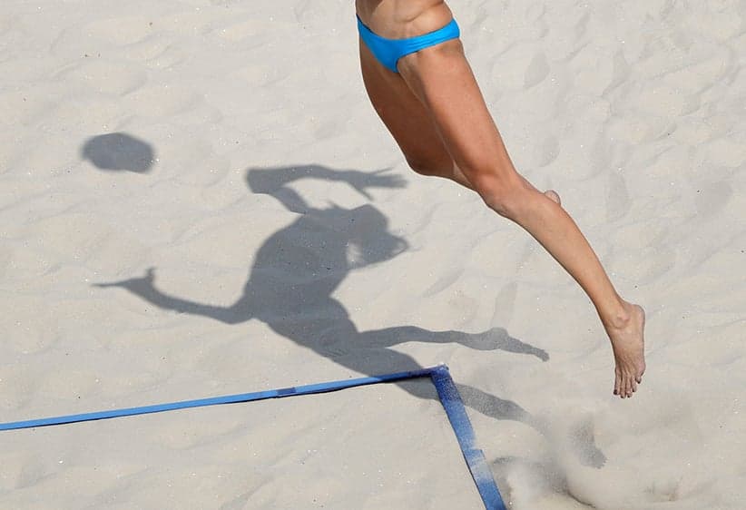 Russia's Ekaterina Birlova casts a shadow on the sand as she serves to Poland during a women's beach volleyball match at the 2016 Summer Olympics in Rio Tuesday, Aug. 9, 2016. (Marcio Jose Sanchez/AP/CP)