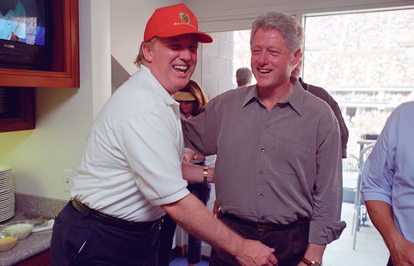 Donald Trump (L) laughs with then U.S. President Bill Clinton at the U.S. Open in Flushing, New York, U.S in this September 8, 2000 handout photo. (Courtesy William J. Clinton Presidential Library/Handout via Reuters)
