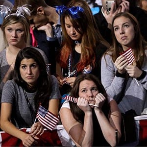 Supporters watch the election results on a larger television monitor during Democratic presidential nominee Hillary Clinton's election night rally in the Jacob Javits Center glass enclosed lobby in New York, Tuesday, Nov. 8, 2016. (Matt Rourke/AP/CP)