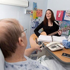 Erin Montgomery sings for Art, a patient in the palliative ward at the Victoria General Hospital, Friday April 8, 2011. Montgomery sings to several patients in the ward, lifting their spirits with music and song. (Tim Krochak/Halifax Chronicle Herald/CP)