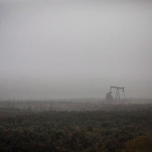 A pumpjack works at a well head on an oil and gas installation on a foggy day near Cremona, Alta., Saturday, Oct. 29, 2016. Oil and gas companies in Alberta are accelerating voluntary reclamation of old well sites and pipelines. (Jeff McIntosh/CP)