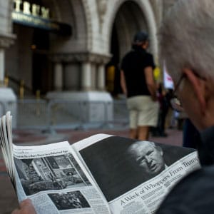 A man reads an article by The New York Times on Donald Trump during a protest outside the new Trump International Hotel at the old post office on October 26, 2016 in Washington, D.C. Republican presidential nominee Donald Trump will attend the hotel's grand opening. (Gabriella Demczuk/Getty Images)