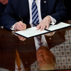 U.S. President Donald Trump signs an executive order during a ceremony with Treasury Secretary Steve Mnuchin at the Treasury Department in Washington, U.S., April 21, 2017. (Aaron P. Bernstein/Reuters)