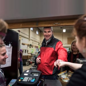 Nova Scotia Premier Stephen McNeil, centre, first-bumps with girls working at the cafe at Corridor Community Options Program during a campaign stop in Halifax on Tuesday, May 9, 2017. (Darren Calabrese/CP)
