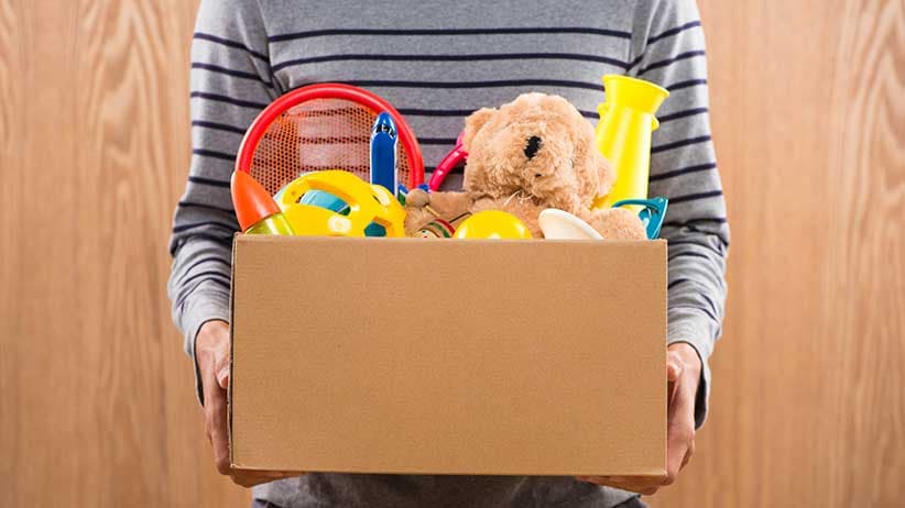 Volunteer holds box containing donated toys