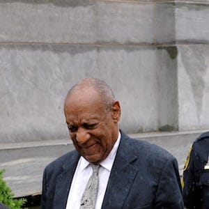 Actor and comedian Bill Cosby walks as his publicist, Andrew Wyatt, raises his fist after a judge declared a mistrial in his sexual assault trial at the Montgomery County Courthouse in Norristown, Pennsylvania, U.S., June 17, 2017. REUTERS/Charles Mostoller - RTS17H2K