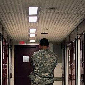 A U.S. soilder stands inside a hallway at Camp 5 detention facility on May 31, 2009 at U.S. Naval Base Guantanamo Bay, Cuba. Camp six is a medium-security facility with the capability of holding in a maximum-security portion of its roughly 60 detainees, based on their compliance with rules, according to the U.S. military. Former child soldier Omar Khadr, the Canadian citizen captured on the battlefield in Afghanistan in 2002 is expected to appear in a military commission hearing tomorrow with the charge of providing support to terrorism after allegedly throwing a grenade that killed a US soldier. This trial marks the first hearing of the Bush-era war crimes tribunals to take place under U.S. President Barack Obama. (Brennan Linsley/Getty Images)
