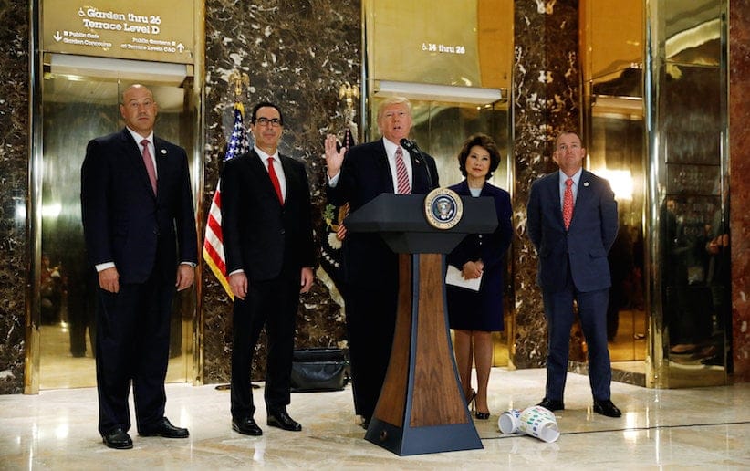 U.S. President Donald Trump is flanked by (L-R) Director of the National Economic Council Gary Cohn, Treasury Secretary Steven Mnuchin, Secretary of Transportation Elaine Chao and Director of the Office of Management and Budget Mick Mulvaney as he speaks about the violence, injuries and deaths at the "Unite the Right" rally in Charlottesville while talking to the media in the lobby of Trump Tower in Manhattan, New York, U.S., August 15, 2017. REUTERS/Kevin Lamarque