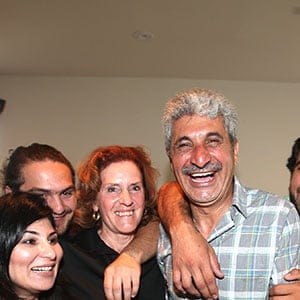 Asad Aryubwal(centre) poses with his family, Husna,16, Robina, Mujeebullah, 24, journalist Carol Off (who featured Aryubwal in her documentary about warlords who were working with the Americans and NATO troops to oust the Taliban) , Muhammad,26, wife Mobina and Hossai in their home. (Vince Talotta/Toronto Sta/Getty Images)