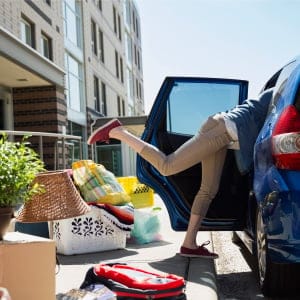 College student reaching in car moving into dorm. (Hero Images/Getty Images)