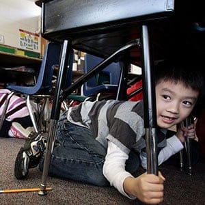 Grade one student, six-year-old Joseph Kim, takes cover under his desk during an earthquake drill at Hollyburn Elementary School in West Vancouver, B.C., on Wednesday January 26, 2011. More than 400,000 British Columbians took part in the drill called "ShakeOut" simultaneously at schools and businesses across the province in the largest earthquake-preparedness program ever held in Canada. (Darryl Dyck/CP)
