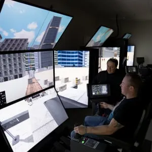 A student sits in the operating chair of a computerized crane simulator at SAIT Campus in Calgary, Alberta. The Crane and Hoisting Equipment Operator - Mobile Crane Apprentice program, teaches operators while use a sim, to manipulate a number of pedals and levers to rotate the crane, and raise and lower its boom and one or more load lines. (Photograph by Chris Bolin)