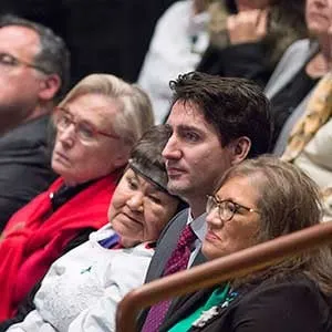 Prime Minister Justin Trudeau sits in the crowd before he delivered an apology on behalf of the Government of Canada to former students of the Newfoundland and Labrador Residential Schools in Happy Valley-Goose Bay, N.L. on Friday, Nov. 24, 2017. THE CANADIAN PRESS/Andrew Vaughan