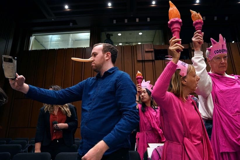 Oliver Mintz-Lowe (L) takes a 'selfie' while protesting with members of Code Pink for Peace before the start of a hearing where U.S. Attorney General Jeff Sessions will testify to the Senate Judiciary Committee in the Hart Senate Office Building on Capitol Hill October 18, 2017 in Washington, DC. Committee members questioned Sessions about conversations he had with President Donald Trump about the firing of former FBI Director James Comey, the Defered Action for Childhood Arrivals (DACA) policy, the ongoing investigation about Russian intereference in the 2016 presidential election by Robert Muller and other subjects. (Chip Somodevilla/Getty Images)