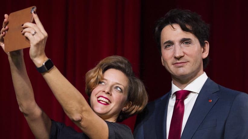 Grevin Montreal museum Managing Director Kathleen Payette poses for a selfie next to a wax sculpture of Prime Minister Justin Trudeau during a ceremony at the museum in Montreal, Tuesday, November 21, 2017. (Graham Hughes/CP)