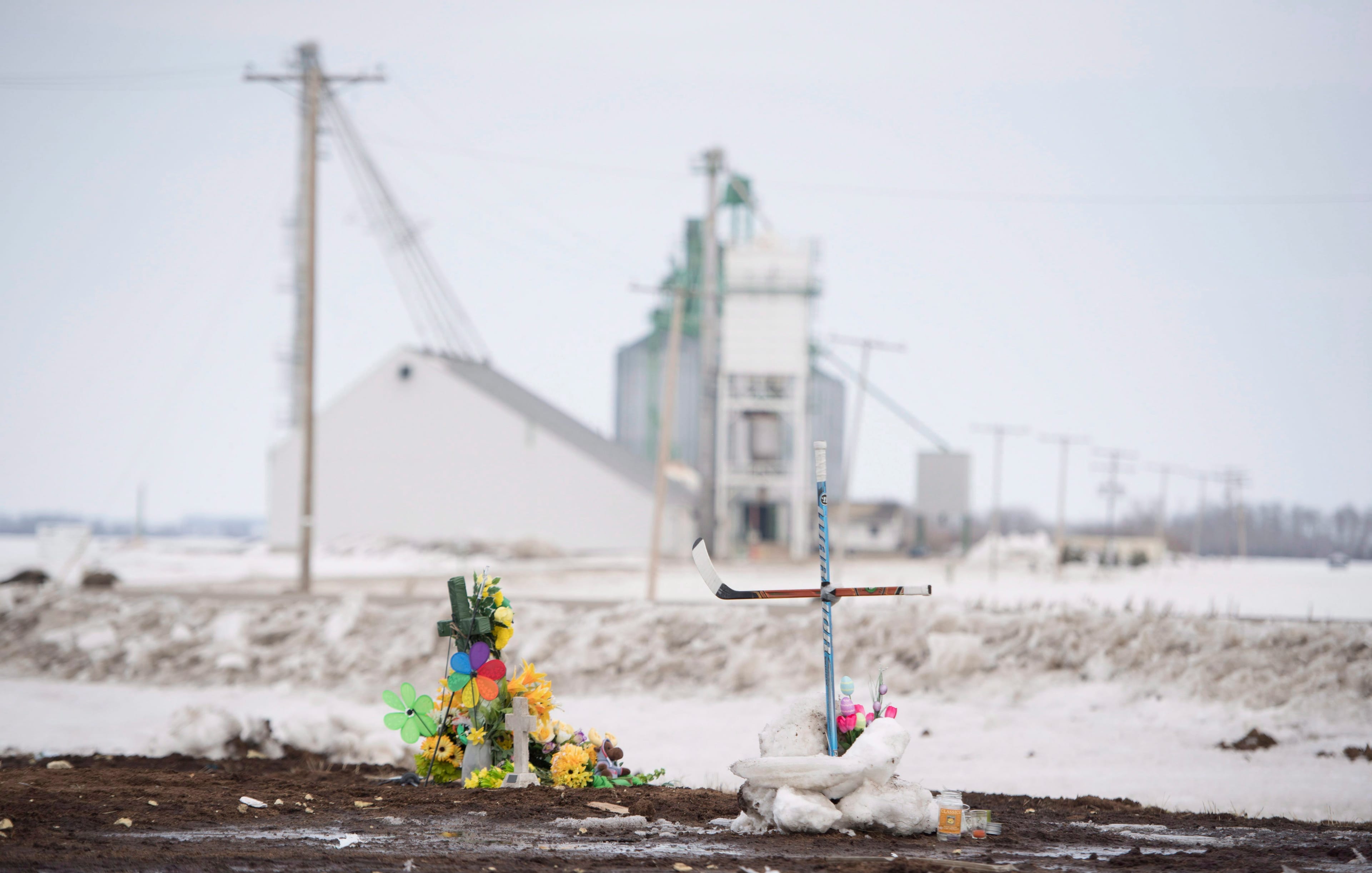 A cross made out of hockey sticks is seen at the intersection of a fatal bus crash near Tisdale, Sask., Monday, April, 9, 2018. (Jonathan Hayward/CP)